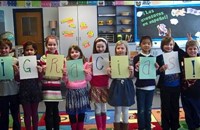Children standing in a line holding up letters that spell 'Gracias'