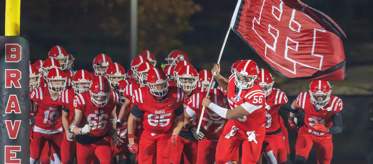 Football Students Running out with Flag